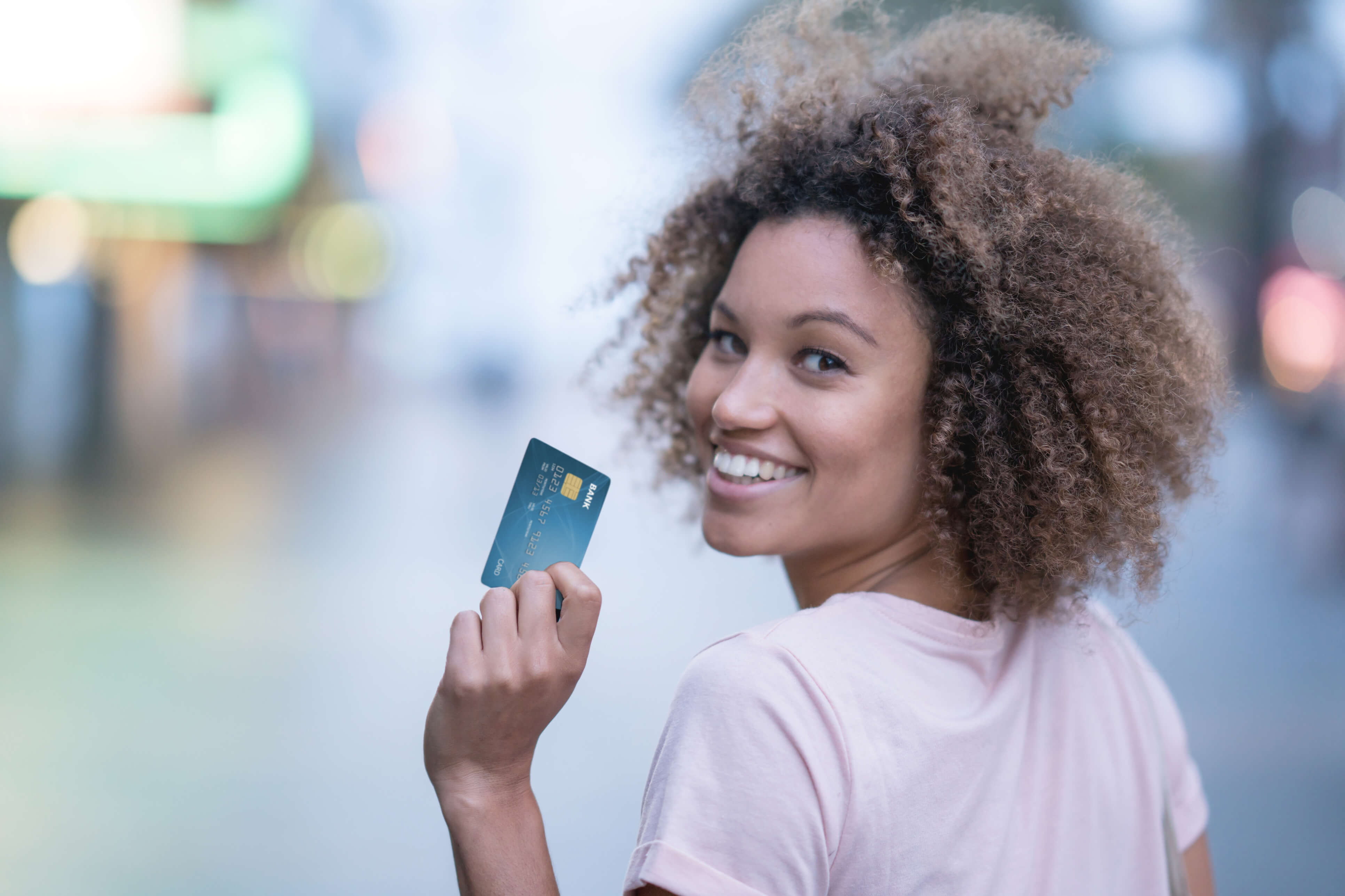 Photo of Woman Turning Around with a Credit Card in her hand